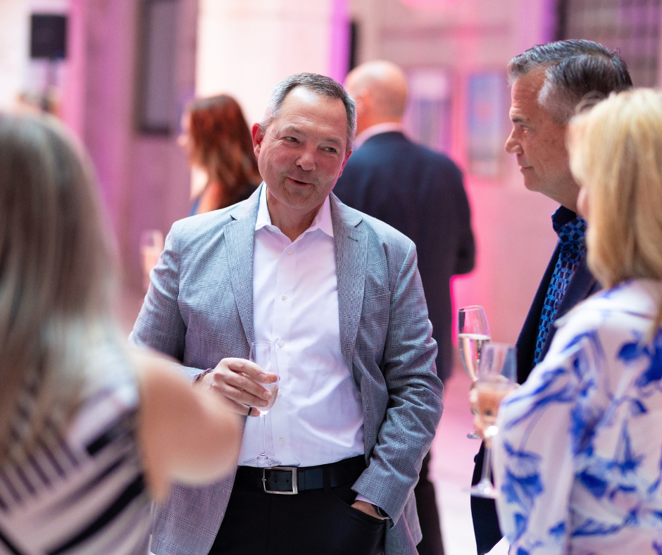 people gathered around, standing and chatting at a sales event