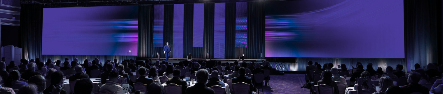 meeting session in a dramatically lit auditorium setup