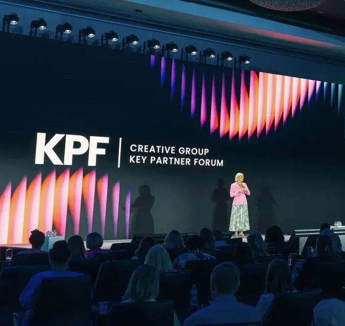 Speaker on the KPF Creative Group Key Partner Forum stage in front of a seated audience.